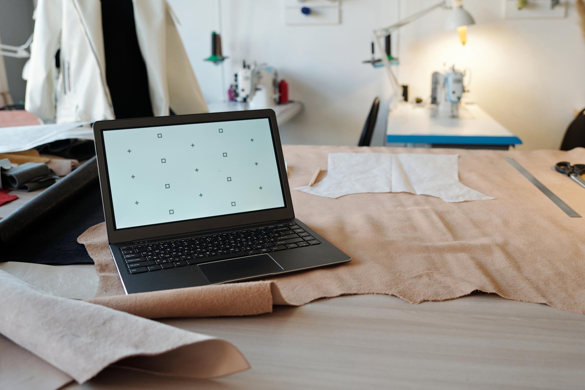 Workshop desk with laptop and embroidered sample