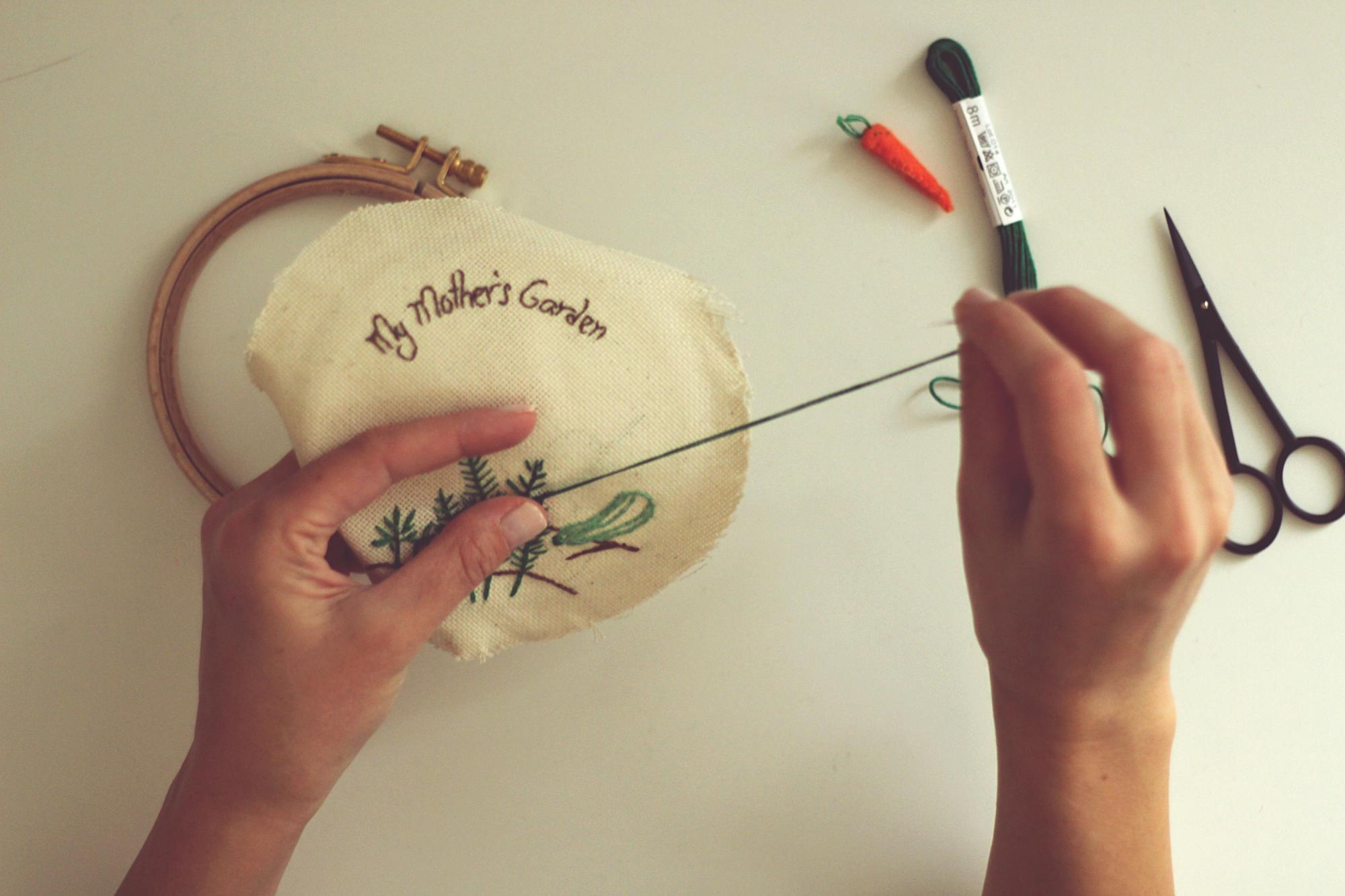Instructor holding embroidered sample in studio